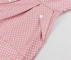 Gros plan d'une robe vintage rose à pois montrant les détails de la poche.