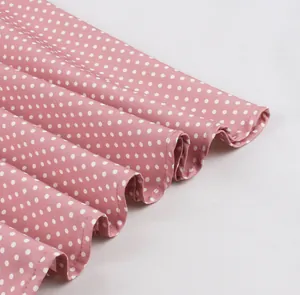 Gros plan sur une robe rétro rose à pois avec un ourlet évasé au design élégant