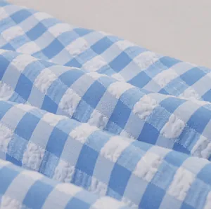 Close-up macro view of blue and white gingham seersucker fabric texture for dress.