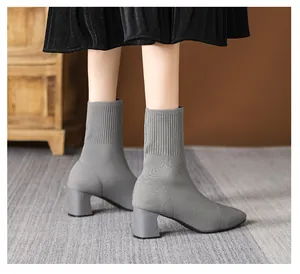 Detailansicht grauer Strick-Sockenstiefel mit dickem Absatz und quadratischer Zehe