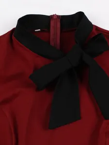 Detailed view showing the black bow tie and collar of a burgundy vintage cotton dress.