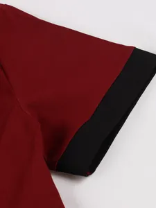 Detailed close-up of wine red vintage dress sleeve featuring black contrast cuff