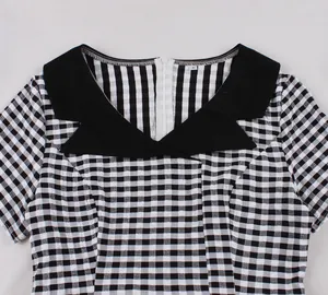 Close-up detail of a retro black and white gingham dress featuring a contrast black collar