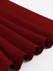 Close-up of vintage wine red cotton dress hem showing fabric texture and pleats