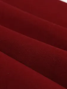 Macro detail showing the smooth texture of burgundy cotton fabric for vintage dress