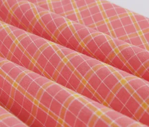 Vista macro detallada de la tela de algodón a cuadros británicos rosa y naranja para vestidos