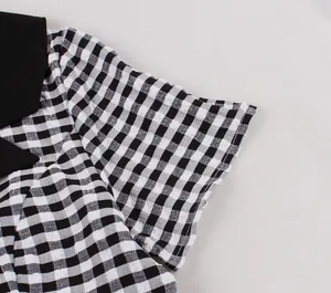Close-up detail of a retro black and white gingham dress with a contrast black collar design