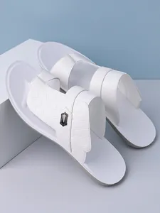 Close-up view of white men's fashion sandals with diamond embossed texture and metal accent