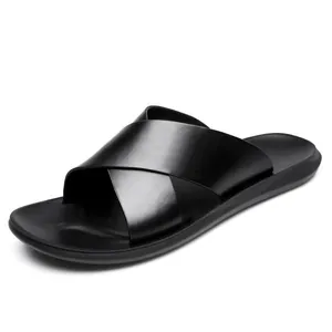 Detailweergave van zwarte heren slippers van zacht leer met gekruiste bandjes en zool