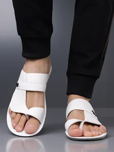 Close-up of white men's sandals featuring an embossed pattern and functional toe loop design.