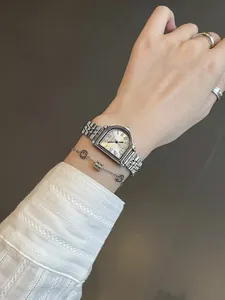 Elegante primer plano de un reloj vintage plateado para mujer con números romanos en la muñeca.