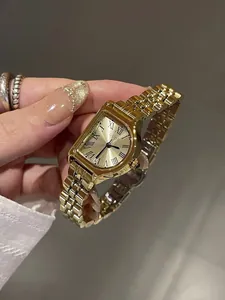 Primer plano del reloj dorado vintage GUOU con números romanos y una elegante correa de metal.