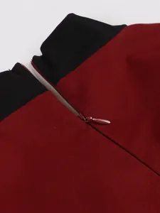 Detailed view of the invisible zipper and black contrast collar on a vintage wine red dress