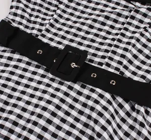 Close-up detail view of retro gingham dress with wide black belt and silver buckle