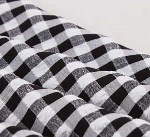 Macro detail of high-quality black and white checkered fabric with textured seersucker weave