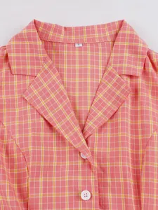 Primer plano de un vestido de cuadros rosa vintage con cuello de solapa clásico