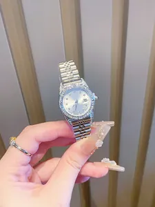 Vista macro de un elegante reloj de mujer plateado con bisel de diamantes y fecha