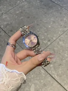 Primer plano del dial rosa y la correa de acero plateado del reloj para mujer IBSO