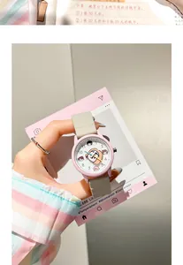 Primer plano de un lindo reloj de cuarzo rosa con esfera de dibujos y correa gris
