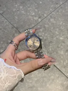 Detalle del reloj IBSO para mujer en acero plateado con esfera dorada y lupa de fecha