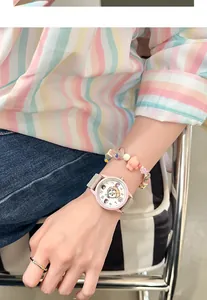 Primer plano de un lindo reloj rosa para estudiantes con esfera de dibujos y correa silicona