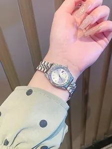 Detalle de reloj para mujer con bisel de pedrería y correa de acero jubilee plata