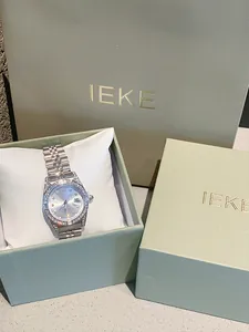 Elegante reloj de mujer plateado con pedrería en caja de regalo verde premium.