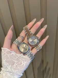 Primer plano de relojes de plata y oro rosa con marcadores de cristal en mano