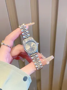 Primer plano detallado de un reloj plateado para mujer con bisel de diamantes