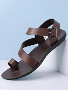 Detailed side view of men's brown leather toe-loop sandals with adjustable buckle strap