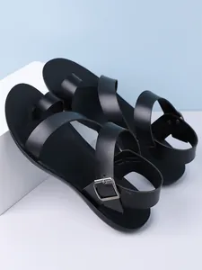 Detailed view of minimalist black men's sandals with adjustable heel strap and toe loop