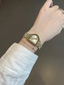 Primer plano de un reloj vintage para mujer en tono dorado con números romanos
