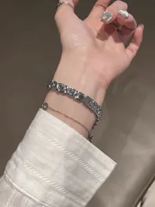 Detalle de un elegante reloj de cuarzo plateado vintage GUOU en la muñeca mujer.