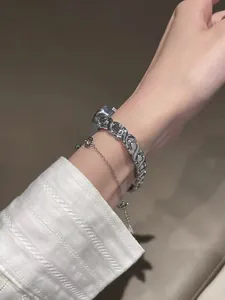 Primer plano de un reloj plateado para mujer con correa de eslabones y pulsera a juego