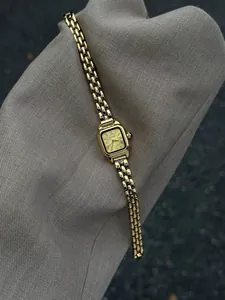 Detailed view of a vintage gold square ladies quartz watch with Roman numerals dial