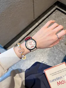 Close-up of a stylish quartz watch and beaded bracelet worn on a wrist