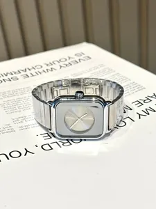Vue détaillée de la montre argentée carrée GUOU avec bracelet métallique sur fond minimaliste