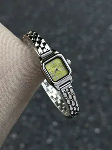 Close-up of retro square women's quartz watch with light green dial and Roman numerals