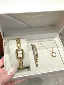 Detailed view of a vintage gold quartz watch and matching jewelry set in an elegant gift box