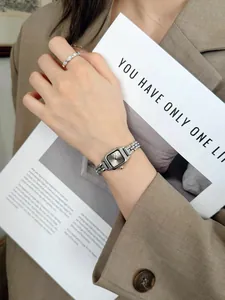 Detail shot of elegant silver square quartz watch with Roman numerals for women
