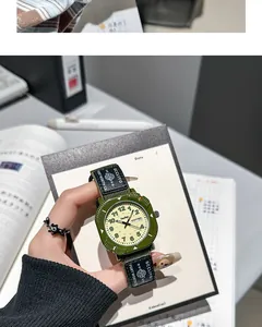Detail view of a green student quartz watch with canvas strap and dual date display