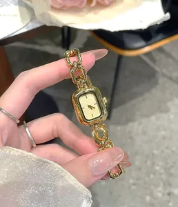 Close-up of a vintage style gold quartz watch for women with elegant chain link strap
