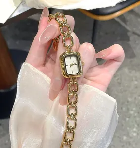 Close-up detail of a vintage minimalist gold quartz watch with a stylish chain strap