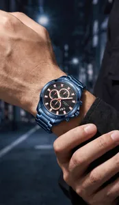 Gros plan d'une montre chronographe en acier bleu avec calendrier au poignet