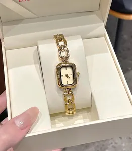 Detailed view of a vintage minimalist gold quartz watch for women with chain strap