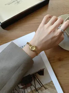 Vue rapprochée élégante d'une montre à quartz dorée vintage au poignet d'une femme