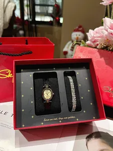 Vintage goldene Damenuhr und schimmerndes Diamantarmband Set in einer roten Luxus-Geschenkbox