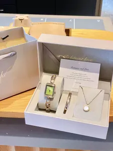 Coffret cadeau bijoux élégant avec montre à cadran vert, bracelet doré et collier.