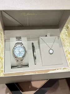 Detailed view of women's silver quartz watch with matching bangle and necklace set