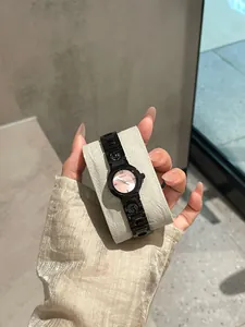 Primo piano di orologio al quarzo da donna nero e rosa con cinturino in acciaio traforato